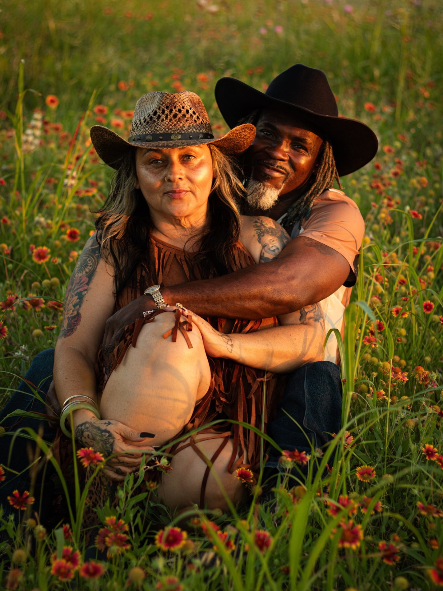 Couple embracing in a Texas wildflower field at golden hour
